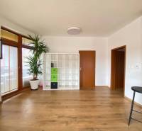 ☎️ 0918197701   Na predaj  elegantný 3 izbový byt priamo v centre Duna - Obývacia izba v 3-izbovom byte s podlahou s dreveným dekorom a bielou policovou skriňou.