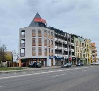 ☎️ 0918197701   Na predaj  elegantný 3 izbový byt priamo v centre Duna - Ulica s budovami, autami a reklamami v Dunajskej Strede.