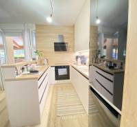 ☎️ 0918/197 701 Predám priestranný  3 izbový  byt s veľkou terasou a m - Kuchyňa s bielymi skrinkami a podlahou s dreveným dekorom v 3-izbovom byte.