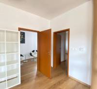 ☎️0918197701  Na prenájom  elegantný 3 izbový byt priamo v centre Duna - Interiér 3-izbového bytu s podlahou s dreveným dekorom a bielou knižnicou.