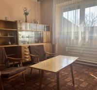 0911 234 656 Predaj rodinný dom v obci Jahodná - Obývacia izba v rodinnom dome s retro nábytkom, záclonami a zdobeným kobercom.