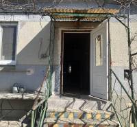 0911 234 656 Predaj rodinný dom v obci Jahodná - Vstup do rodinného domu v Jahodnej s bielymi dverami a malou terasou.