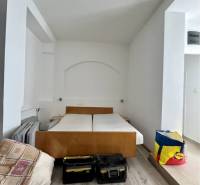 ZNÍŽENÁ CENA!!! Apartmánový dom na predaj vo Veľkom Mederi - Spálňa s posteľou, kufríkmi a podlahou s dreveným dekorom v rodinnom dome.