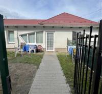 ZNÍŽENÁ CENA!!! Apartmánový dom na predaj vo Veľkom Mederi - Rodinný dom vo Veľkom Mederi s červenou strechou, trávnikom a vonkajším posedením.