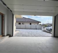 Jedinečný 5 izbový dom na predaj v TOP lokalite-GARDEN TOWN - Rodinný dom s otvorenou garážou, modernou dlažbou a autom v exteriéri.
