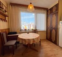 Na predaj: CENTRUM veľký 3 izb.byt + BALKON + ŠATNIK - Útulná kuchyňa s kvetinovými závesmi, rustikálnymi poličkami, stolom a pôsobí súčasťou 3-izbového bytu.