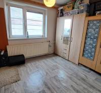 NA PREDAJ 6 izbový rodinný dom v obci Hrušovany  - Izba v rodinnom dome s podlahou s dreveným dekorom, vstavanými skriňami a oknom.