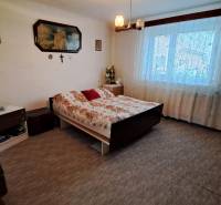 NA PREDAJ 6 izbový rodinný dom v obci Hrušovany  - Spálňa v rodinnom dome s posteľou, záclonami a nástennými dekoráciami.