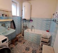 NA PREDAJ 6 izbový rodinný dom v obci Hrušovany  - Kúpeľňa v rodinnom dome s umývadlom, vaňou a práčkou. Modré obklady, úložné koše.