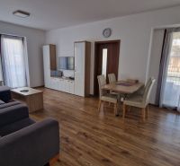 Rekreačný apartmán Vys. Tatry- HREBIENOK RESORT I. - 92 m2 -3-izbový - Obývacia izba Rekreačného apartmánu s podlahou s dreveným dekorom a priestrannou sedačkou.