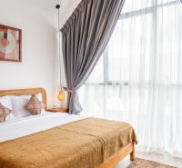 PREDAJ 3KK Investičná zariadená vila s bazénom BALI-Canggu Padonan - Svetlá spálňa vo Vile s veľkým oknom, bielou posteľou a závesmi.