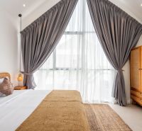PREDAJ 3KK Investičná zariadená vila s bazénom BALI-Canggu Padonan - Spálňa vo vile s veľkým oknom, závesmi, lôžkom a dreveným nábytkom.
