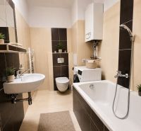 Bývanie s vlastnou predzáhradkou – zariadený 2-izbový byt (62+33 m²) - Kúpeľňa v 2-izbovom byte s vaňou, práčkou a dekoráciami.