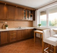 Bývanie s vlastnou predzáhradkou – zariadený 2-izbový byt (62+33 m²) - Kuchyňa v 2-izbovom byte s podlahou s dreveným dekorom a hnedými skrinkami.