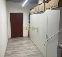 Na predaj obchodný priestor v centre Malaciek - Úzka miestnosť v budove s podlahou s dreveným dekorom a úložnými skriňami.
