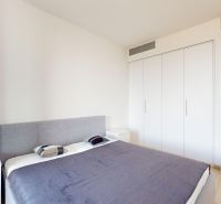Byt v minimalistickom štýle s výhľadom na hrad - Spálňa v 2-izbovom byte na ulici Čulenova, obsahuje posteľ a skrine.