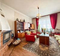 Rodinný dom s pozemkom 727m2, Tatranská ul. - Trenčín - Obývačka v rodinnom dome s krbom a podlahou s dreveným dekorom, zariadená starožitným nábytkom.