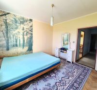 3 izbový byt 77m2 s balkónom Trenčín - Kubrá  - Spálňa v 3-izbovom byte s lesnou tapetou a podlahou s dreveným dekorom.
