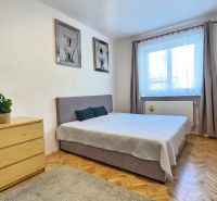 Predaj dvojizbový byt v Banskej Štiavnici, pod Kalváriou - Spálňa v 2-izbovom byte s podlahou s dreveným dekorom, dekorácie a úložný nábytok.