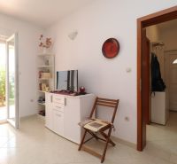 Chorvátsko, Vodice - zariadený bungalov, výhľad na more - Interiér rodinného domu s bielym nábytkom, televízorom a otvorenými dverami na záhradu.