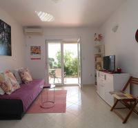Chorvátsko, Vodice - zariadený bungalov, výhľad na more - Interiér rodinného domu s pohovkou, televíziou a výhľadom do záhrady.