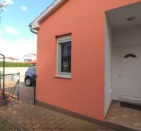 Chorvátsko, Vodice - zariadený bungalov, výhľad na more - Rodinný dom vo Vodiciach s oranžovou fasádou a bielymi dverami pri vstupe.