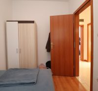 Chorvátsko, Vodice - zariadený bungalov, výhľad na more - Spálňa v rodinnom dome s posteľou, šatníkovou skriňou a podlahou s dreveným dekorom.