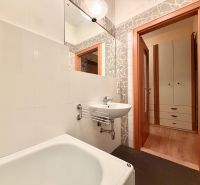 Na prenájom vybavený 2i byt, ul. Moravská, Bratislava - Kúpeľňa so svetlými obkladmi a vaňou v 2-izbovom byte, dvere vedú do chodby.