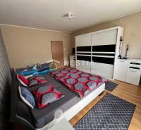 NOVINKA Priestranný 3-izbový byt (99 m²) s pozemkom, terasou, 2 balkón - Spálňa v 3-izbovom byte s veľkou skriňou a podlahou s dreveným dekorom.