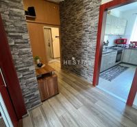 NOVINKA Priestranný 3-izbový byt (99 m²) s pozemkom, terasou, 2 balkón - Chodba 3-izbového bytu s podlahou s dreveným dekorom a kameňom obloženými stenami.