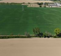 Trhovište – 5.894 m2 POZEMOK na mobilný dom so stavebným potenciálom  - Rekreačné pozemky v Trhovišti s rozľahlými zelenými a hnedými poľami a stromami.