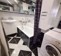 NA PRENÁJOM 1 IZBOVÝ TEHLOVÝ BYT, 34 M2, KOŠICE - ŠACA - Kúpeľňa s čiernobielymi dlaždicami, umývadlom, vaňou a práčkou v 1-izbovom byte.