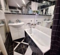 NA PRENÁJOM 1 IZBOVÝ TEHLOVÝ BYT, 34 M2, KOŠICE - ŠACA - Kúpeľňa v 1-izbovom byte s vaňou, umývadlom a tmavým obkladom.