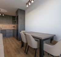 Moderný 2-izbový byt s balkónom, Ovocné sady - Kuchyňa v 2-izbovom byte so skrinkami, stolom a podlahou s dreveným dekorom.