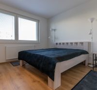 Moderný 2-izbový byt s balkónom, Ovocné sady - Spálňa v 2-izbovom byte s posteľou, lampou a podlahou s dreveným dekorom.