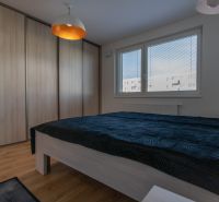 Moderný 2-izbový byt s balkónom, Ovocné sady - Spálňa v 2-izbovom byte s posteľou, vstavanou skriňou a podlahou s dreveným dekorom.