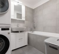 Moderný 2-izbový byt s balkónom, Ovocné sady - Kúpeľňa v 2-izbovom byte s práčkou, umývadlom, vaňou a úložným priestorom.