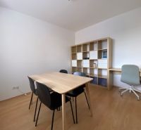 Prenájom 2 izbový 78 m2 + 30 m2 terasa,novostavba Koliba,zariadený - Interiér 2-izbového bytu s čiernymi stoličkami, pracovným stolom a podlahou s dreveným dekorom.
