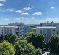 Predaj, Luxusný 4 izbový byt, 180 m2 + 25 m2, Condominium Renaissance - Pohľad na moderné bytovky v Bratislave - Karlovej Vsi obklopené zeleňou a modrou oblohou.