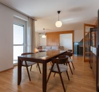 Zariadený 4-izbový byt s balkónmi a parkovaním - Štýlová jedáleň s podlahou s dreveným dekorom a moderným nábytkom v 4-izbovom byte.