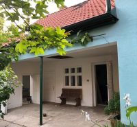 Štýlový 3-izbový rodinný dom po rekonštrukcii v obci Majcichov - Rodinný dom v Majcichove na ulici Majcichov so záhradou, lavičkou a červenou strechou.