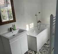 Štýlový 3-izbový rodinný dom po rekonštrukcii v obci Majcichov - Kúpeľňa v rodinnom dome s bielou vaňou, umývadlom a zdobeným zrkadlom.