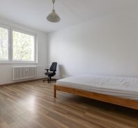 Renovovaný 3-izbový byt, Ružinov - Svetlá spálňa s posteľou a pracovnou stoličkou, podlaha s dreveným dekorom.
