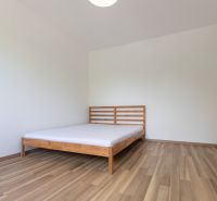 Renovovaný 3-izbový byt, Ružinov - Spálňa s posteľou, podlaha s dreveným dekorom, v 3-izbovom byte.