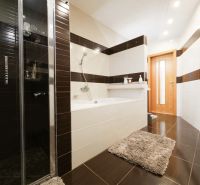 Nadštandardný 5-izbový RD - veľkorysý pozemok - moderné technológie - Kúpeľňa v rodinnom dome s vaňou, sprchovacím kútom a dlažbou s dreveným dekorom.