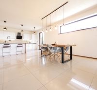 Nadštandardný 5-izbový RD - veľkorysý pozemok - moderné technológie - Kuchyňa v Rodinnom dome s jedálenským stolom, barovými stoličkami a svetlými dlaždicami.