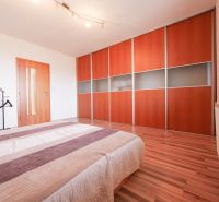 Nadštandardný 5-izbový RD - veľkorysý pozemok - moderné technológie - Spálňa v rodinnom dome s vstavanou skriňou a podlahou s dreveným dekorom.