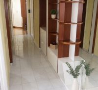 2-izbový byt, 51 m², samostatné izby, tichý, výhľad do zelene,K.Adlera - Chodba so zabudovanými policami a dlažbou v 2-izbovom byte s rastlinnými dekoráciami.