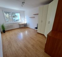 2-izbový byt, 51 m², samostatné izby, tichý, výhľad do zelene,K.Adlera - Izba s podlahou s dreveným dekorom, veľkými oknami, skriňou a písacím stolom.