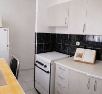 2-izbový byt, 51 m², samostatné izby, tichý, výhľad do zelene,K.Adlera - Kuchyňa v 2-izbovom byte s bielymi skrinkami a jedálenským stolom.
